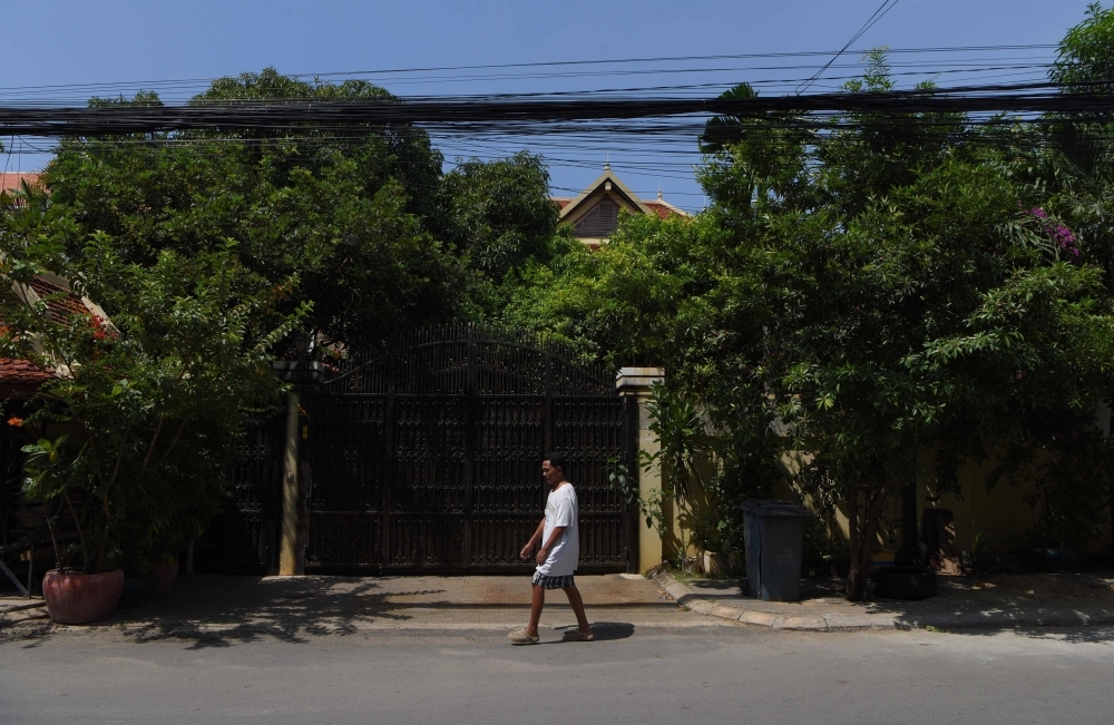 A Cambodian man walks past former opposition leader Kem Sokha’s house in Phnom Penh on Sunday.-AFP