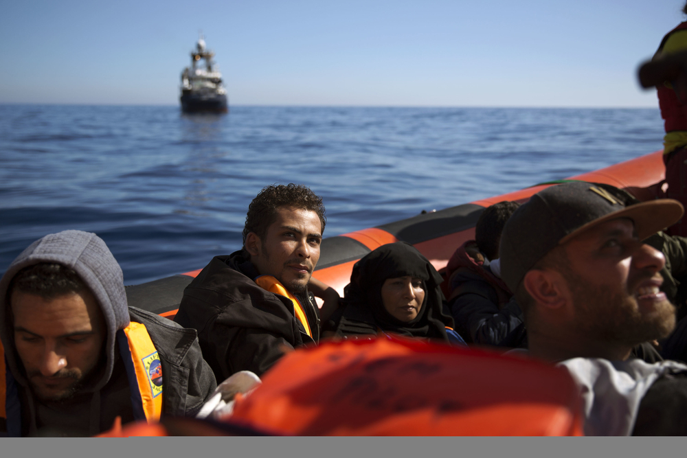 Refugees from Libya sit inside a rescue boat from the Spanish NGO Proactiva Open Arms after being rescued from a wooden boat sailing out of control in the Mediterranean Sea about 18 miles north of Sabratha. — AP