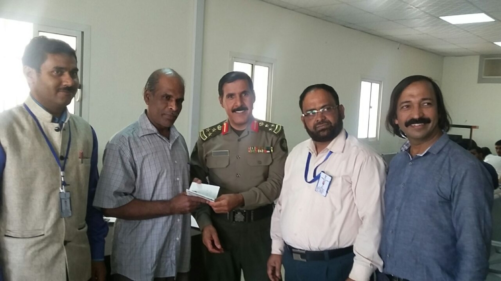 Mohammed Mustafa Rasheed receives his exit paper from Brig. Mohammed Othman Al-Quraishi in Riyadh. Prominent Indian social worker Shihab Kottukad is seen at right.
