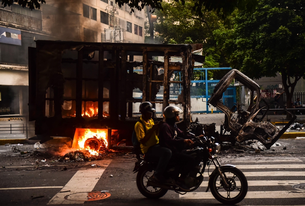 A view of a burned truck during clashes between opposition activists and the police in Caracas on Tuesday. — AFP