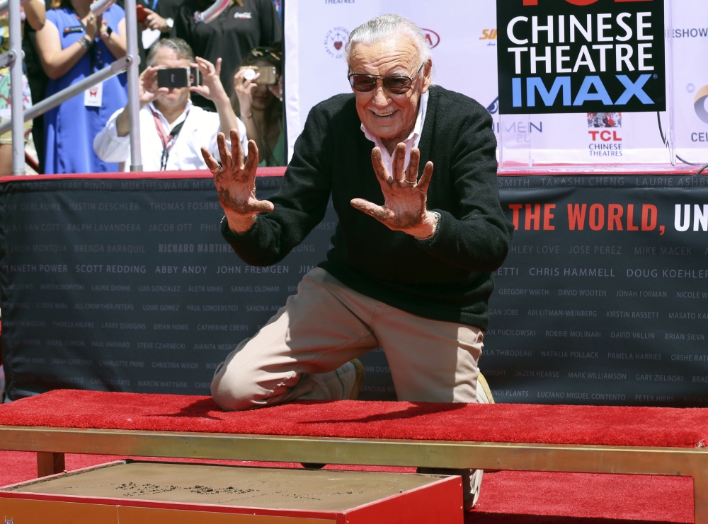 Stan Lee raises his hands after placing them in cement at his hand and footprint ceremony at the TCL Chinese Theatre in Los Angeles, California on Wednesday. - AP
