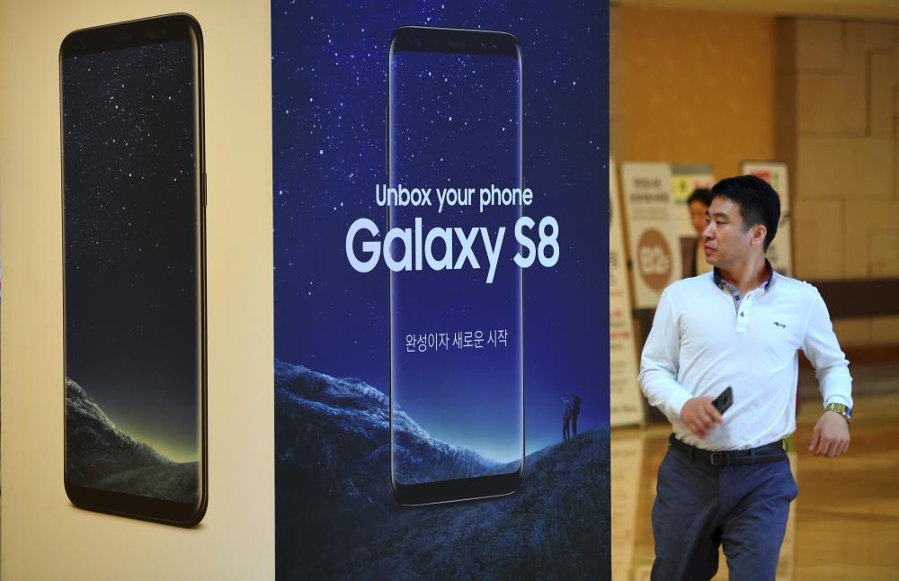 A man walks past an advertisement for the Samsung Galaxy S8 at the company's showroom in Seoul. — AFP