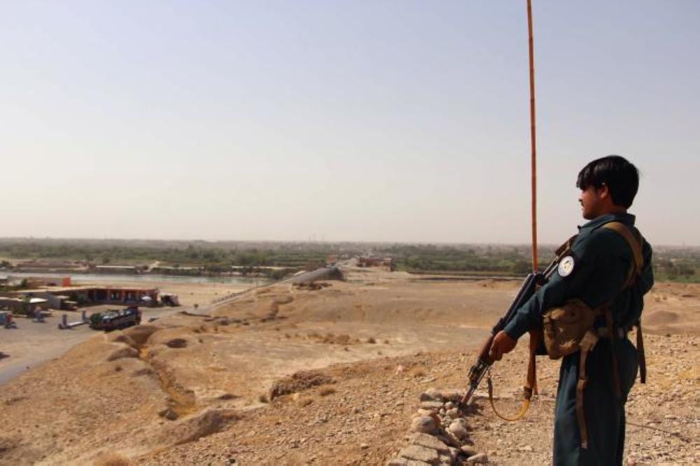 An Afghan policeman stands guard as he keep watches amid an ongoing battle with Taliban militants in the Gereshk district of Helmand province on Saturday. — AFP