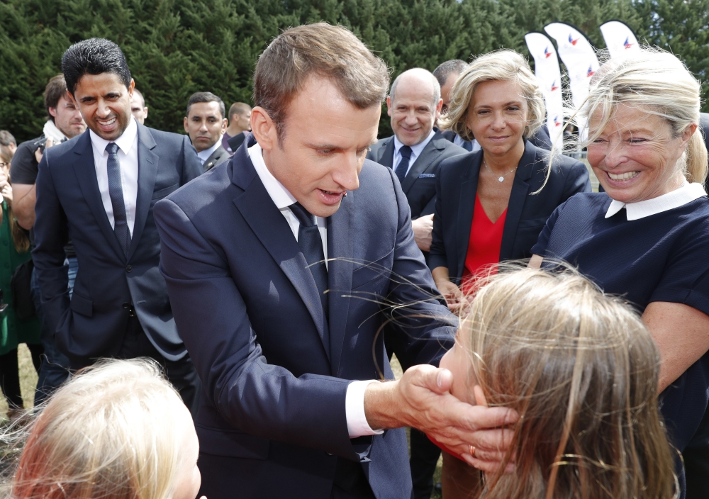 French President Emmanuel Macron greets while PSG President Nasser Al-Khelaifi, left, stands behind him as he attends at a charity holiday program event in Moisson, east of Paris, France, Thursday. Macron is welcoming the likely arrival of Brazilian soccer star Neymar at Paris-Saint Germain in a record $262 million deal. — AP