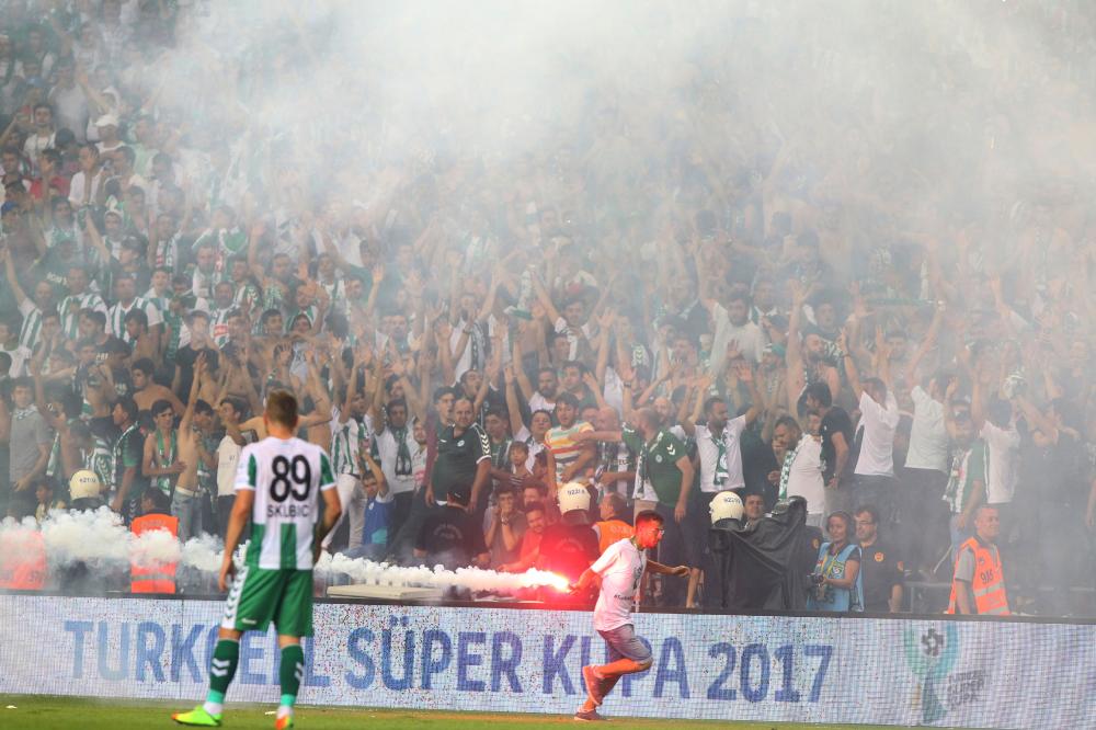 A supporter runs with a burning flare as football fans invade the pitch during the Turkish Super Cup final football match between Besiktas and Konyaspor at Samsun 19 Mayis Stadium in Samsun, Turkey on Sunday last.  Turkish authorities on Thursday ordered the implementation of new security measures at key football matches after last weekend's Super Cup was marred by a pitch invasion and fighting between rival fans. — AFP