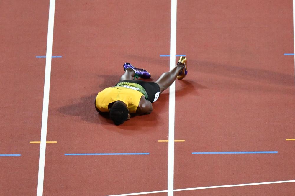 Usain Bolt lies on the track after injuring himself at the London Stadium Saturday. — AFP