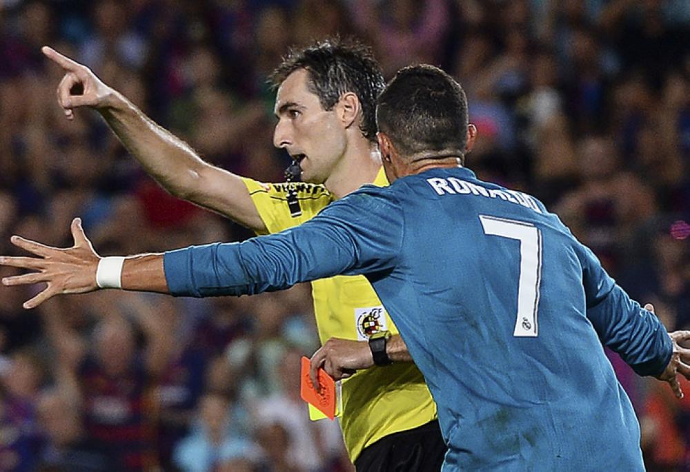 Real Madrid’s Cristiano Ronaldo (R) gestures after receiving a red card by referee Ricardo de Burgos Bengoetxea during the first leg of the Spanish Supercup football match against FC Barcelona at the Camp Nou Stadium in Barcelona Sunday. — AFP