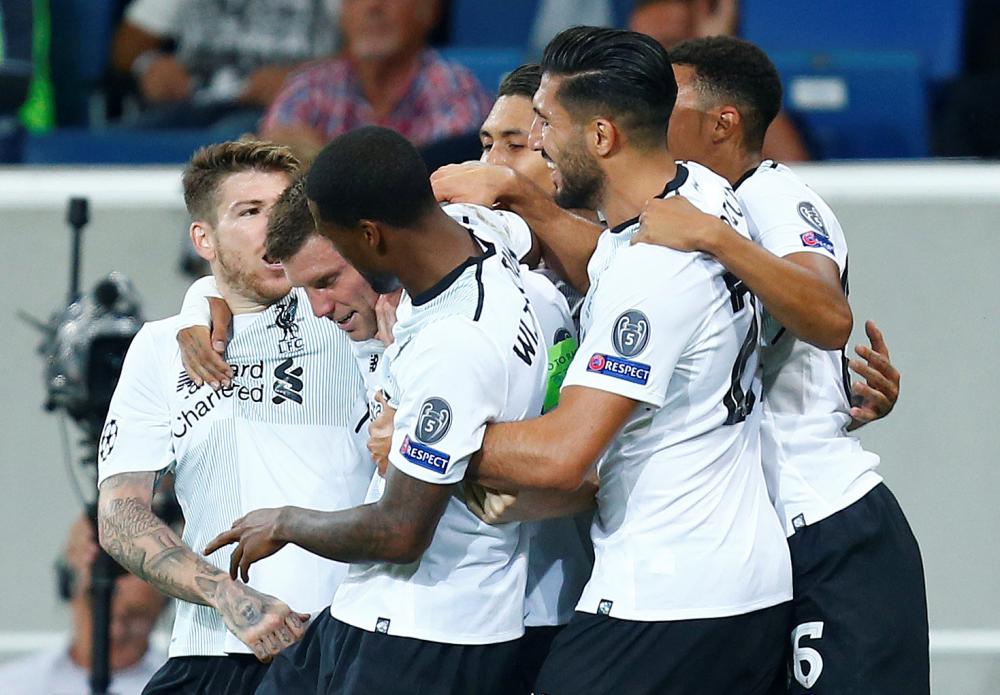 Liverpool’s James Milner celebrates scoring their second goal with teammates against Hoffenheim during their Champions League match in Sinsheim, Germany, Tuesday. — Reuters