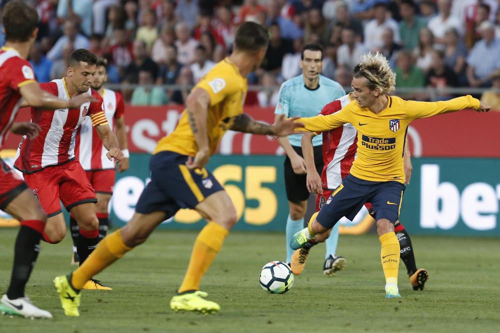 Atletico de Madrid’s Antoine Griezmann (R) controls the ball during the Spanish league match against Girona FC at the Montilivi Stadium in Girona Saturday. — AFP
