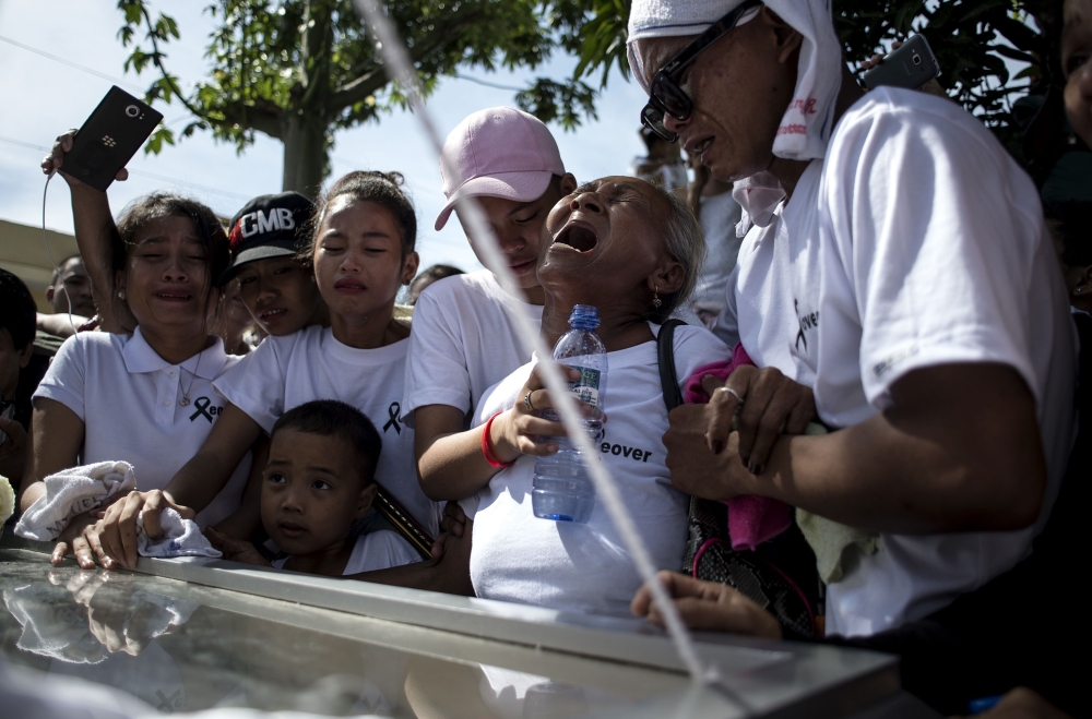 Elvira Miranda, center, mother of Leover Miranda, an alleged drug dealer who was killed on Aug. 3, 2017, cries during the burial of Leover at the Manila North Cemetery on Sunday. — AFP