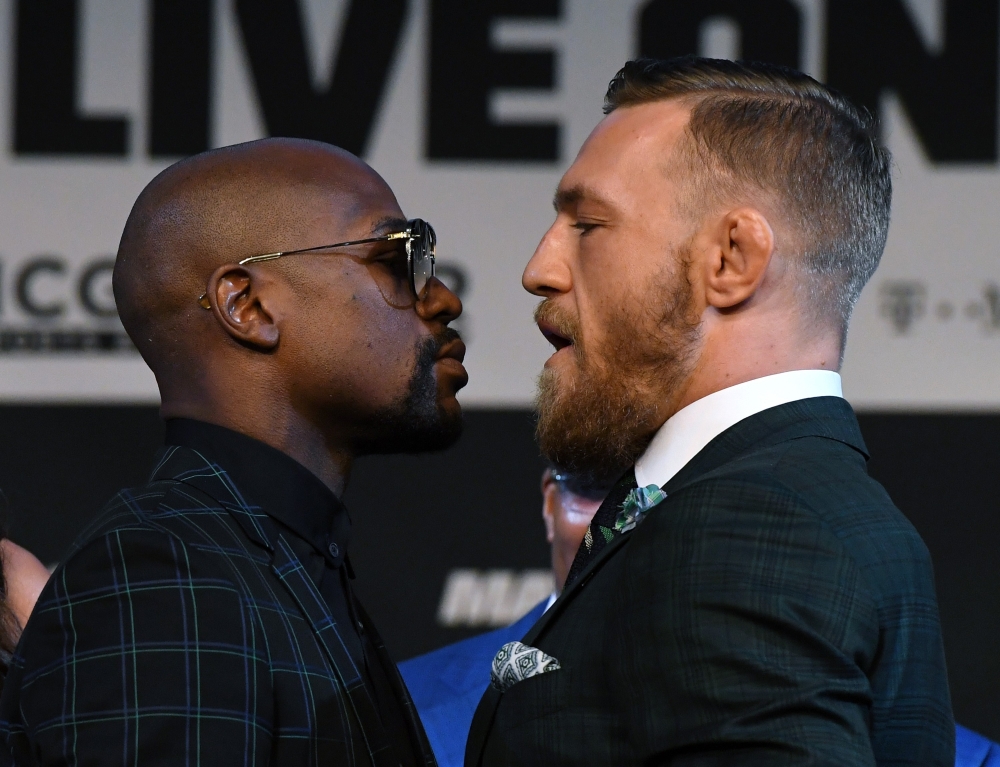 Boxer Floyd Mayweather Jr. (L) and UFC lightweight champion Conor McGregor face off during a news conference at the KA Theatre at MGM Grand Hotel & Casino on Wednesday in Las Vegas, Nevada. The two will meet in a super welterweight boxing match at T-Mobile Arena on Aug. 26 in Las Vegas.  — AFP