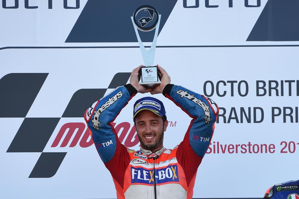 Ducati Team’s Italian rider Andrea Dovizioso lifts the first place trophy on the podium after the MotoGP race of the British Grand Prix at Silverstone circuit in Northamptonshire Sunday. — AFP