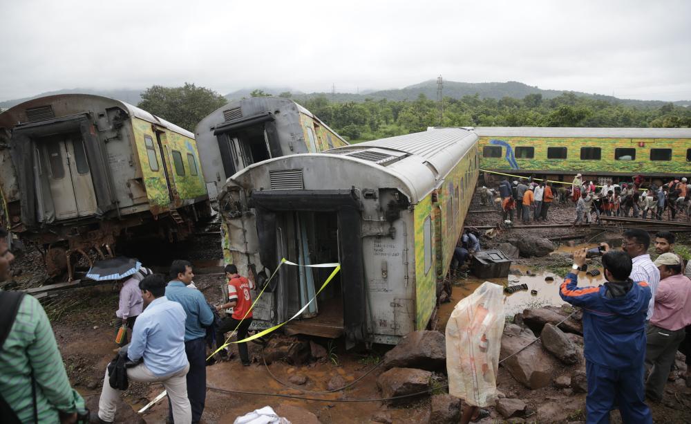 Workers repair the track near upturned coaches of the Duronto Express in Asangaon, some 70 km from Mumbai, Tuesday. — AP