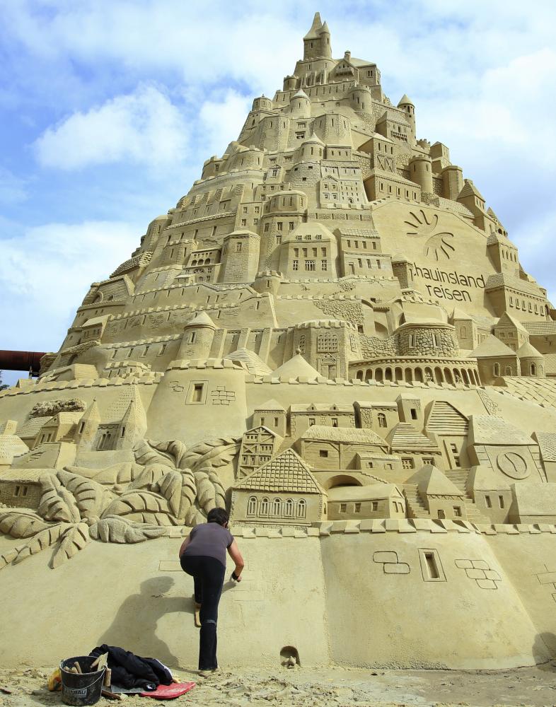 Jack Brockbank, the official judge of Guinness World Records stands next to the world's highest sandcastle (16.68 metres)  in Duisburg, western Germany Friday. — Reuters