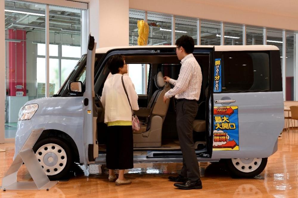 Yoko Kojima's Daihatsu Tanto 'kei car' doubles as a van for her part-time flower delivery business. - AFP