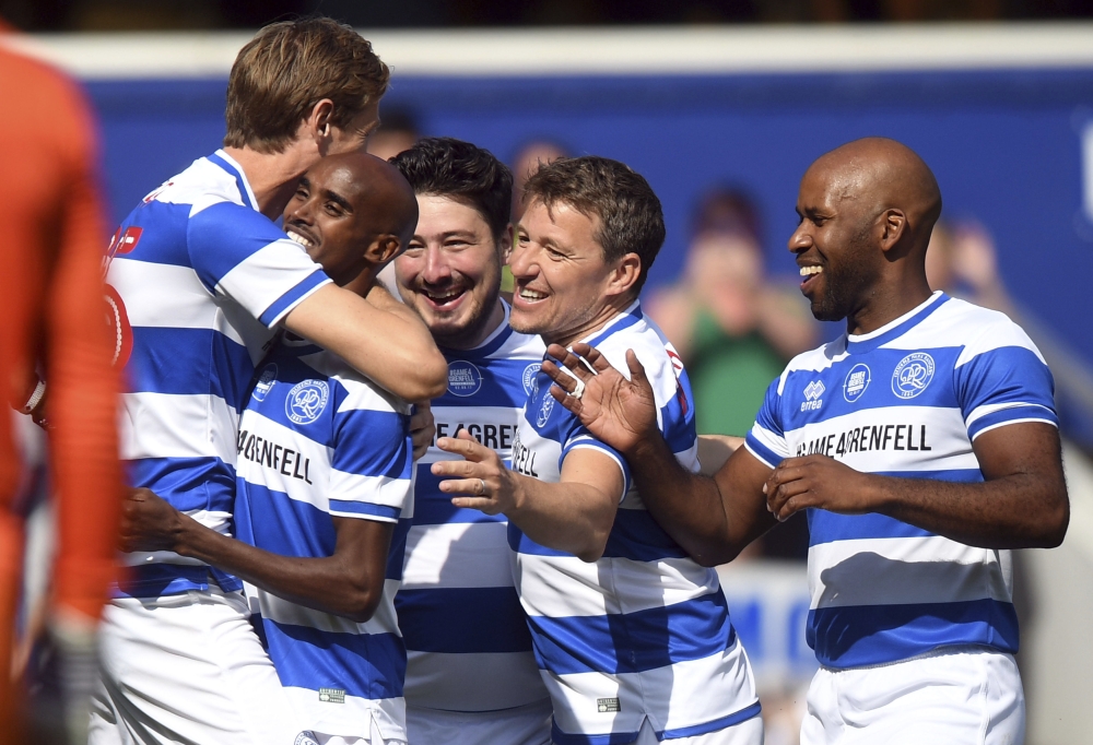 Team Ferdinand celebrate after Sir Mo Farah, 2nd left, scored the first goal of the match during Game4Grenfell, a charity football match to raise funds for Grenfell Tower survivors at QPR's Loftus Road stadium in London on Saturday. - AP