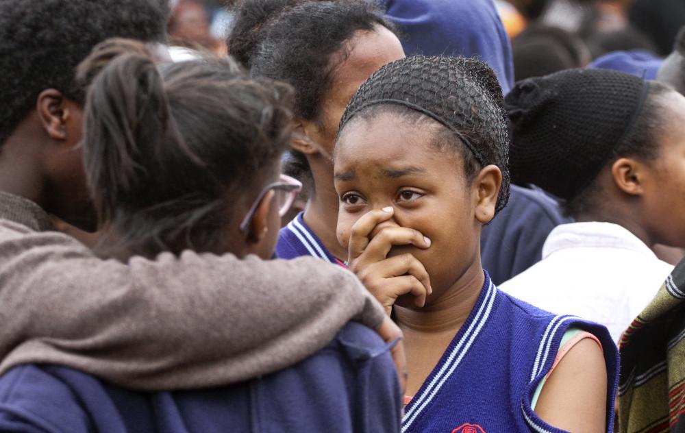 A student gestures as she stands with others following a fire at the Moi Girls High School in Nairobi on Saturday. — AP