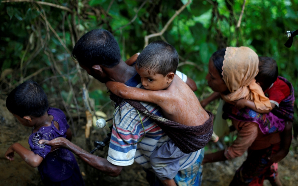 Rohingya refugees climb up a hill after crossing the Bangladesh-Myanmar border in Cox's Bazar, Bangladesh. — Reuters