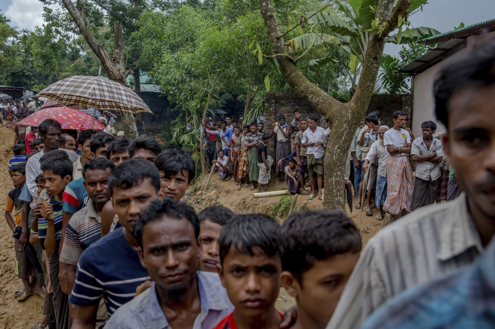 Newly arrived Rohingya wait for their turn to collect building material for their shelters distributed by aid agencies in Kutupalong refugee camp, Bangladesh, on Wednesday. — AP