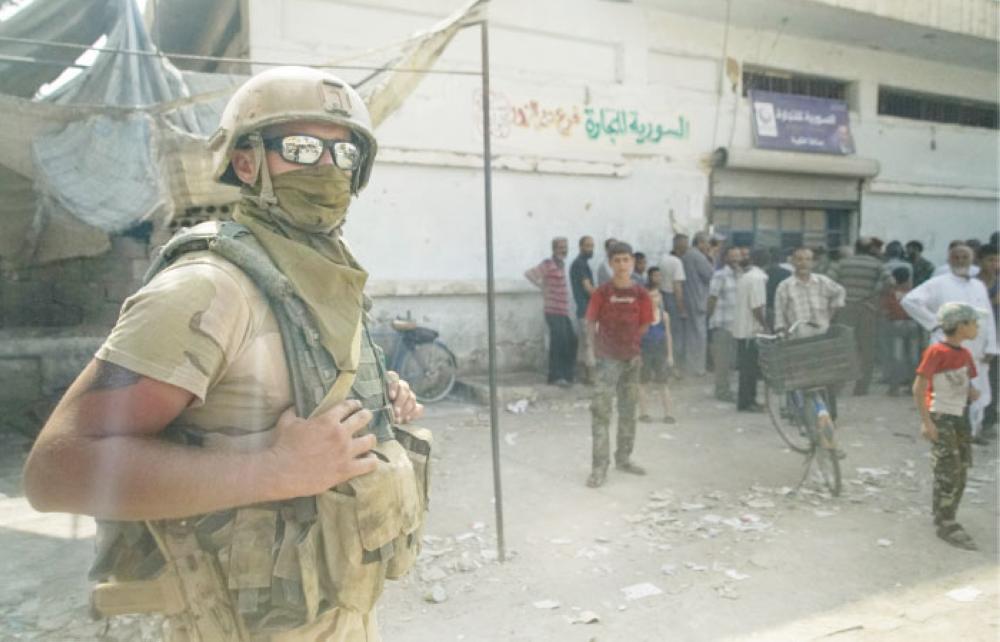 


A Russian soldier guards the area at a city market in Deir Ezzor, Syria. — AP