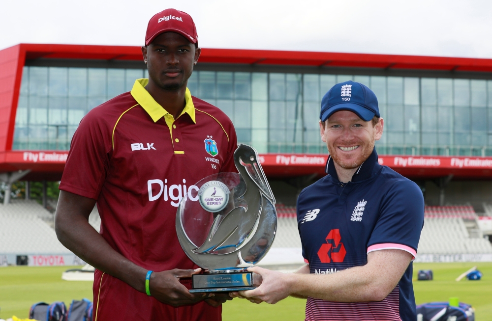 West Indies captain Jason Holder and England captain Eoin Morgan pose with the ODI trophy. — Reuters