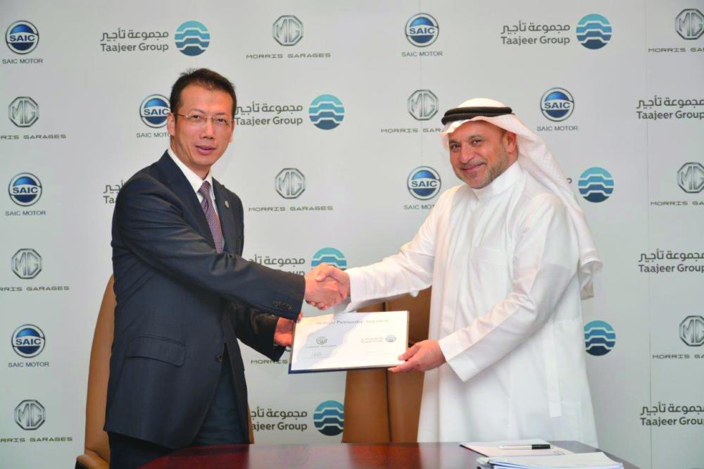 Dr. Saleh Malaika, chairman of Taajeer Group, and Mat Lei, vice president SAIC Motor International, shake hands after the signing of agreement