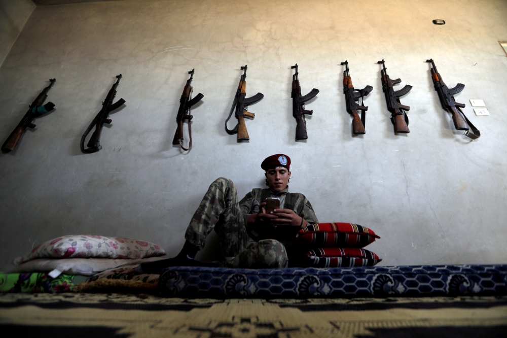 A fighter from Free Syrian Army chats on his mobile in Hazwan town in Aleppo, Syria. — Reuters