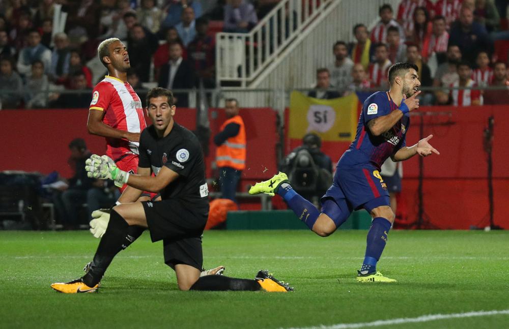 Barcelona’s Luis Suarez (R) celebrates scoring their third goal against Girona during their Spanish league football match in Girona Saturday. — Reuters