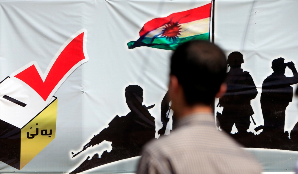 A man looks at a banner supporting the referendum for independence of Kurdistan in Irbil, Iraq, on Sunday. — Reuters