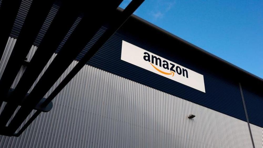 An Amazon logo hangs on a wall outside a company fulfillment center near London in this file photo. — AFP