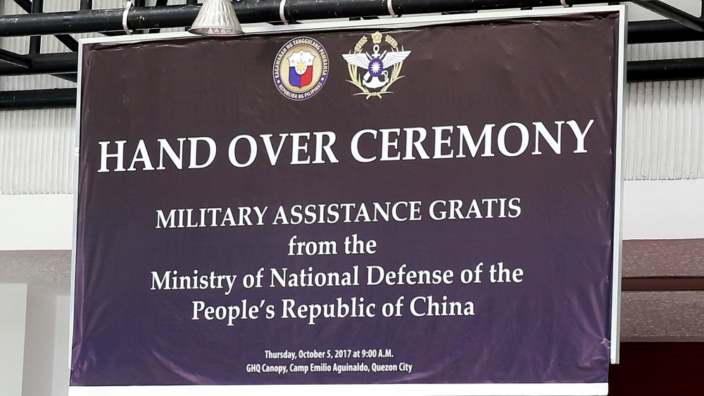In this Oct. 5, 2017 photo, a tarpaulin, showing the logo of the Philippine Defense Department, top left, and that of Taiwan’s Ministry of Defense, top right, is hung from the canopy of the General Headquarters of the Armed Forces of the Philippines for the turnover ceremony of hundreds of Chinese-made assault rifles by China to the Philippines at Camp Aguinaldo in suburban Quezon city, northeast of Manila, Philippines.— AP
