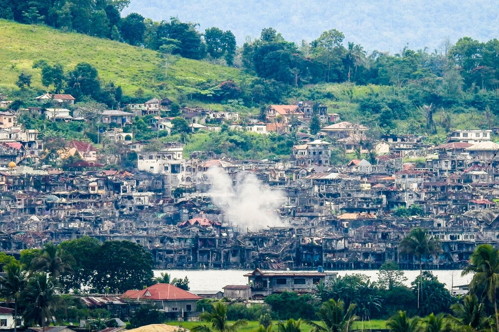 Smoke billows from destroyed buildings after government troops fired mortars at a Daesh position in Marawi on the southern island of Mindanao, Philippines, on Sunday. — AFP