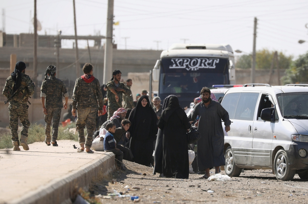 People gather along a road as they flee Raqa. — Reuters