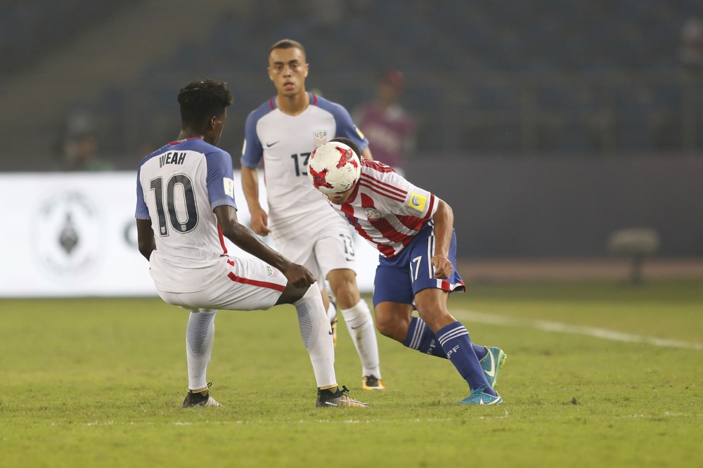 Paraguay's Fernando Cardozo heads the ball as US's Timm Weah tackles during their FIFA U-17 World Cup match in New Delhi, India, Monday. — AP 