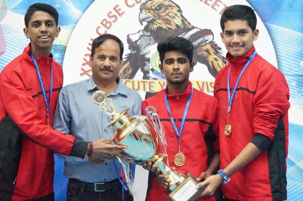 Holding the trophy, IISJ boys pose with their physical education teacher and coach Vijender Singh. Seen from left are Joel Therattil Joy, Vijender Singh, Jadeer Hassan and Mohammed Ranees Basheer. — SG