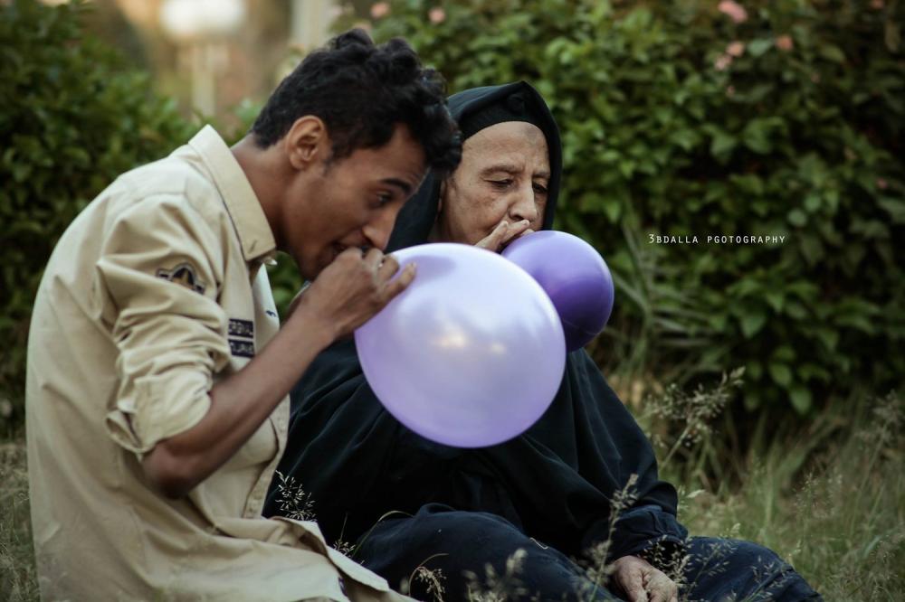 Egyptian grandson and grandmother blowing balloons together. — Courtesy: 3BDALLA Photography