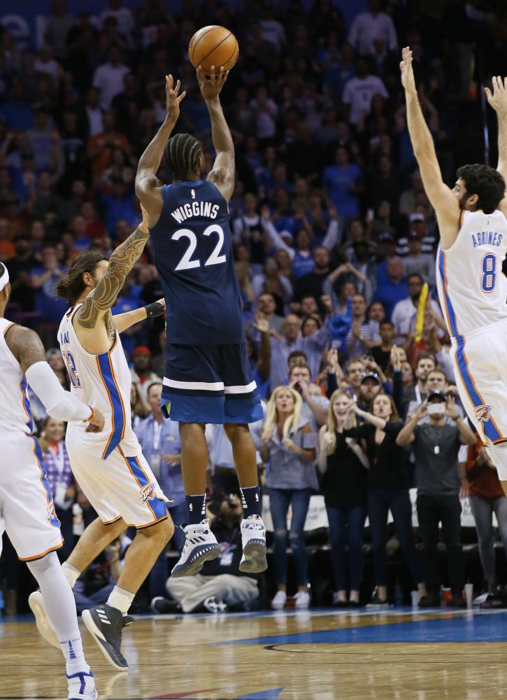 Minnesota Timberwolves’ guard Andrew Wiggins shoots the game-winning shot between Oklahoma City Thunder’s center Steven Adams (L) and guard Alex Abrines (R) during their NBA game in Oklahoma City Sunday. — AP