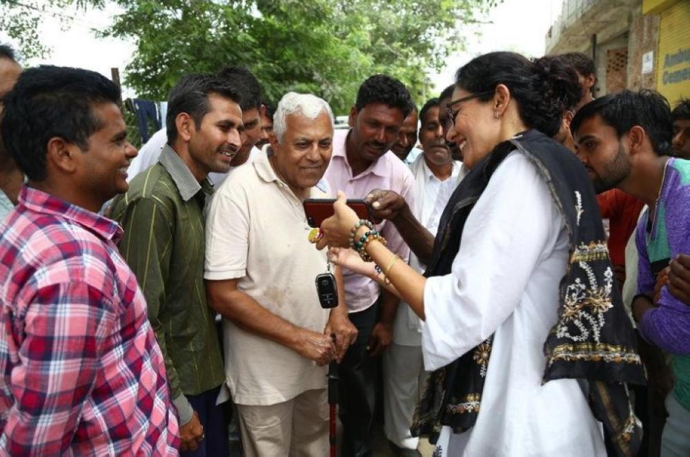 Village head Chhavi Rajawat shows her father [center] and other villagers something on her phone, Rajasthan, India. — Thomson Reuters Foundation