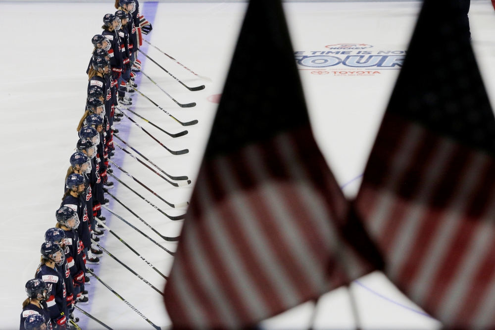 The US women's national hockey team stands for the national anthem before their 