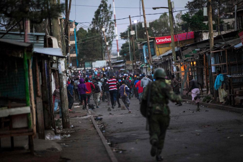 Supporters of Kenya's opposition National Super Alliance (NASA) run from police  as they demonstrate following the announcement of results of a presidential election re-run in Kibera on Monday. — AFP