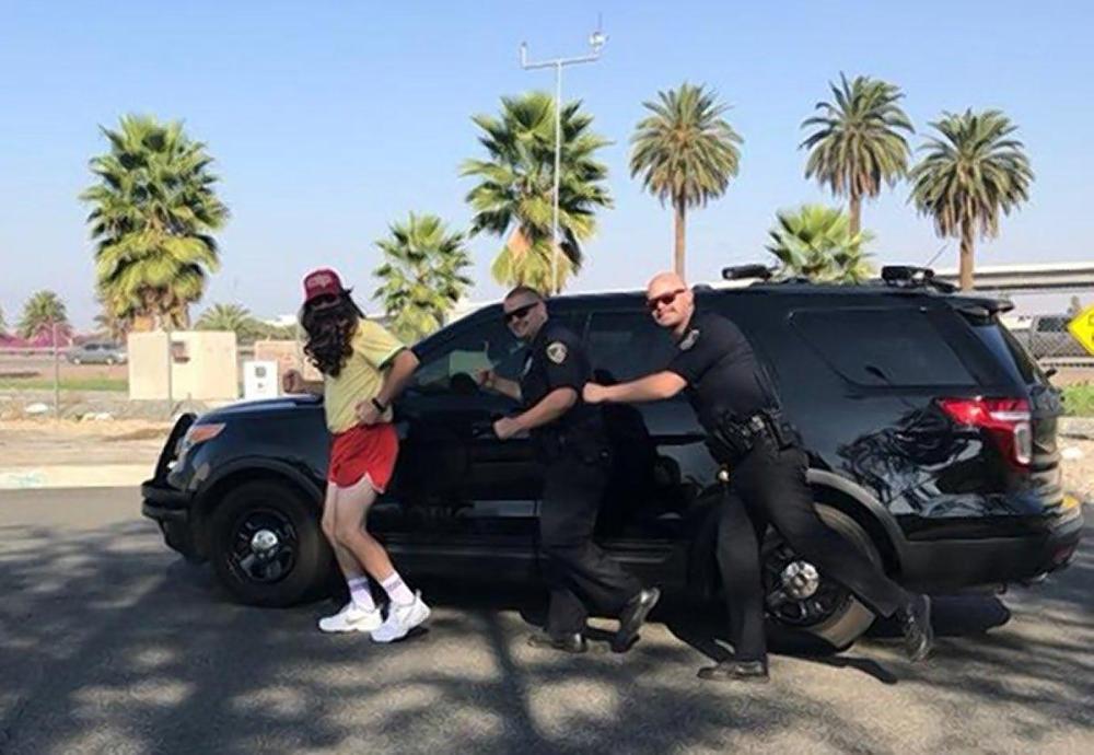 Riverside cops jokingly engage a jogger dressed as Forrest Gump in a slow-speed foot chase in Riverside, California on Tuesday.
