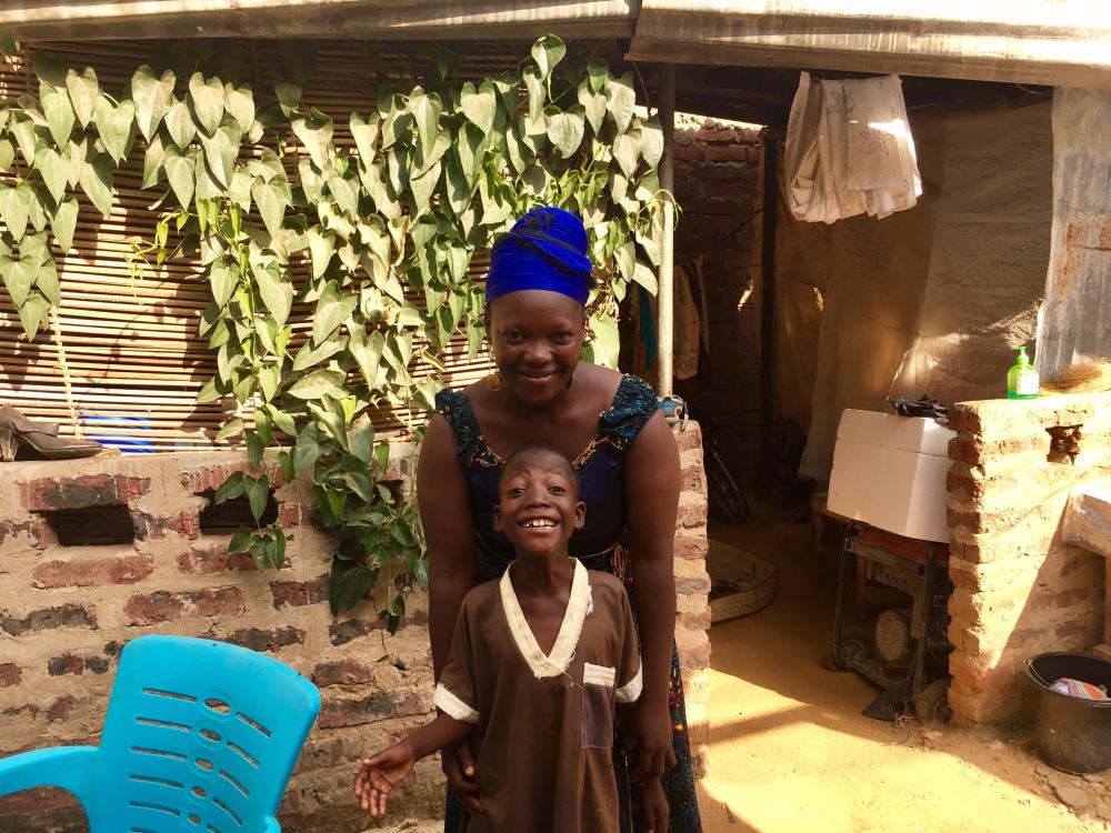 Koutu Saimon and her son Wheener, 8, stand in the courtyard of their house in N'Djamena, Chad. - Thomson Reuters Foundation