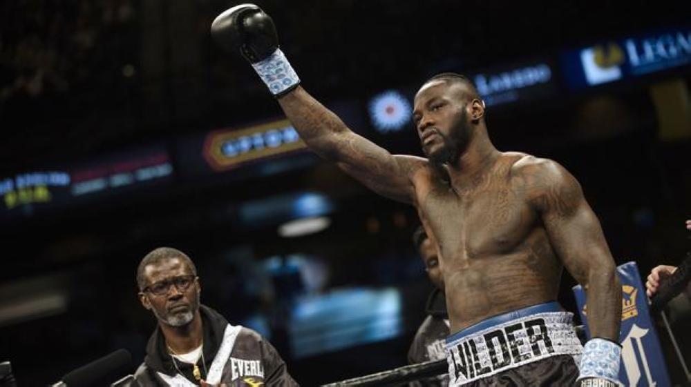 Deontay Wilder raises his glove before his heavyweight title fight against Gerald Washington in this file photo. — AP