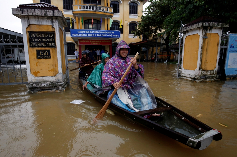 Officials sail a boat out of a submerged local government building after typhoon Damrey hits Vietnam in Hue city, Vietnam, on Sunday. — Reuters