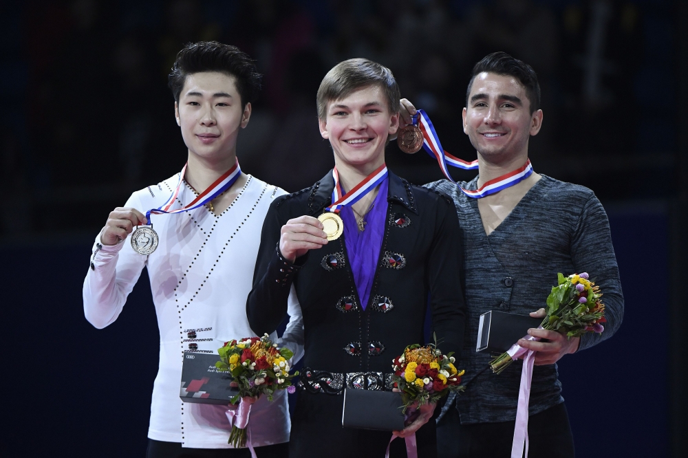 First place winner Mikhail Kolyada of Russia(C), second place winner Jin Boyang of China(L) and third place winner Max AAron of the US (R) show their medals during an award ceremony at the Cup of China ISU Grand Prix of Figure Skating in Beijing on Saturday. — AFP
