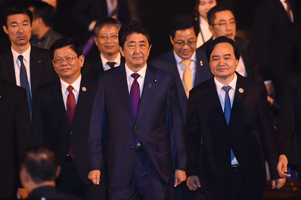 Japan's Prime Minister Shinzo Abe (C) arrives at the international airport ahead of the Asia-Pacific Economic Cooperation (APEC) Summit in the central Vietnamese city of Danang on Thursday. — AFP