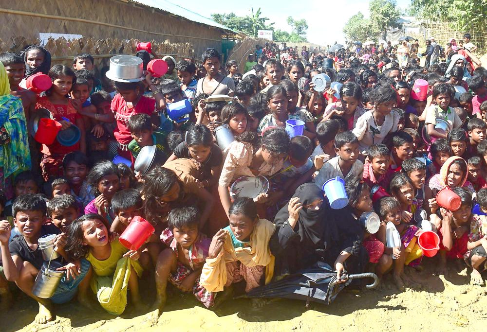 Rohingya refugees wait for food aid at Thankhali refugee camp in Bangladesh’s Ukhia district on Tuesday. — AFP