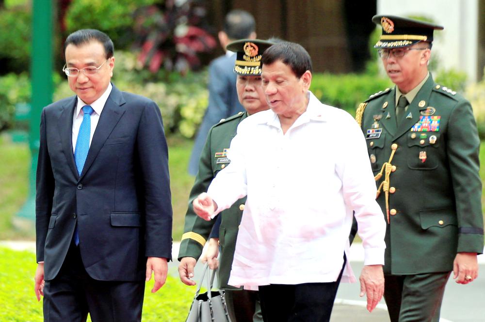 Philippine President Rodrigo Duterte walks with Chinese Premier Li Keqiang upon arrival during Li Keqiang’s official visit, at the Malacanang presidential palace in Manila, Philippines, on Wednesday. — Reuters