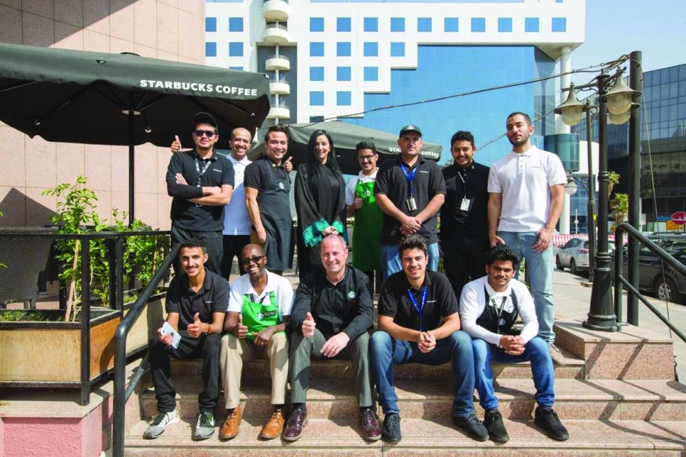 Senior Starbucks executives with some Saudi employees
