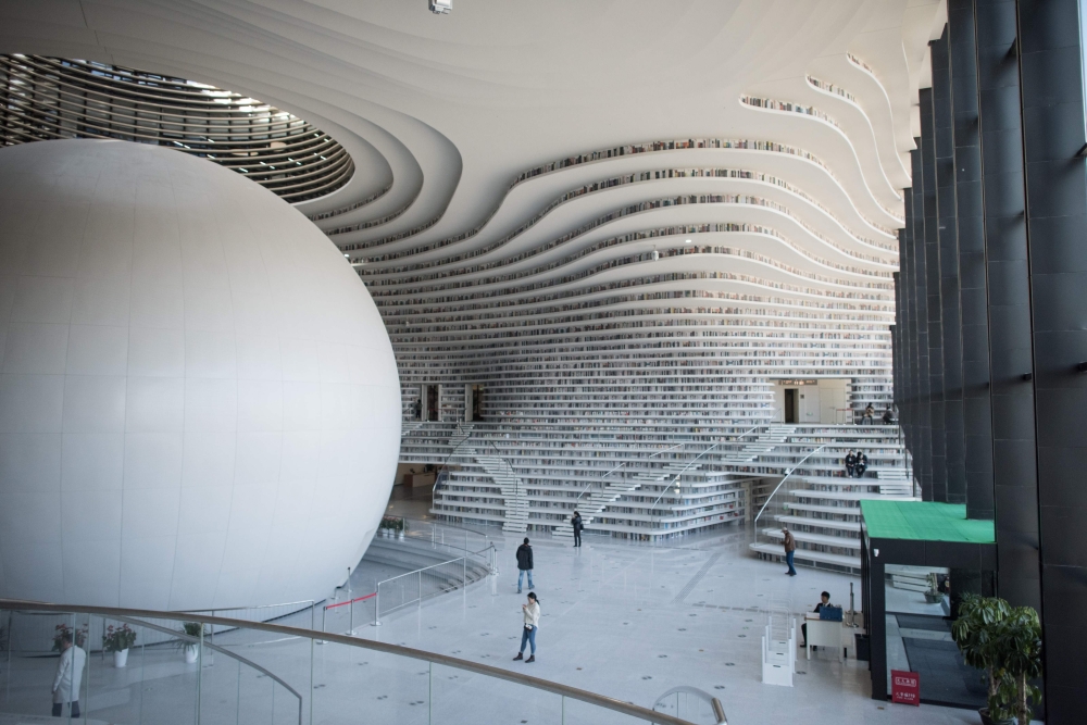 A general view of the Tianjin Binhai Library. A futuristic Chinese library has wowed book lovers around the world with its white, undulating shelves rising from floor to ceiling, but if you read between the lines you'll spot one problem. Those rows upon rows of book spines are mostly images printed on the aluminium plates that make up the backs of shelves. — AFP
